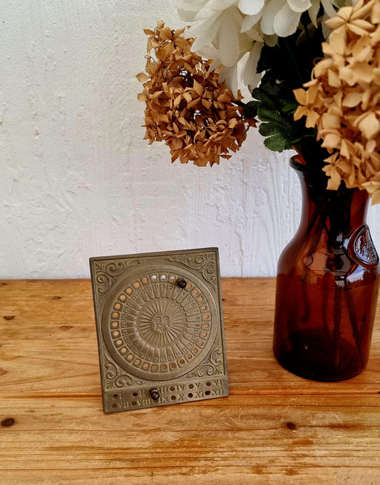 Calendrier perpétuel vintage en laiton décor soleil