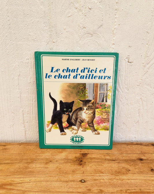 Livre enfant vintage illustré Casterman Le chat d’ici et le chat d’ailleurs couverture verte avec chat noir et chat tigré années 70