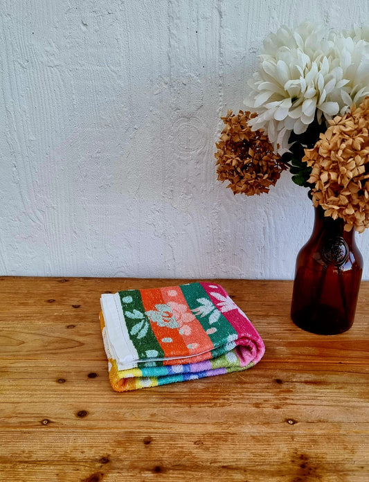 Serviette de bain vintage années 70 à rayures multicolores et fleurs stylisées brodée MD, en coton éponge. les kitscheries brocante en ligne livraison france et belgique